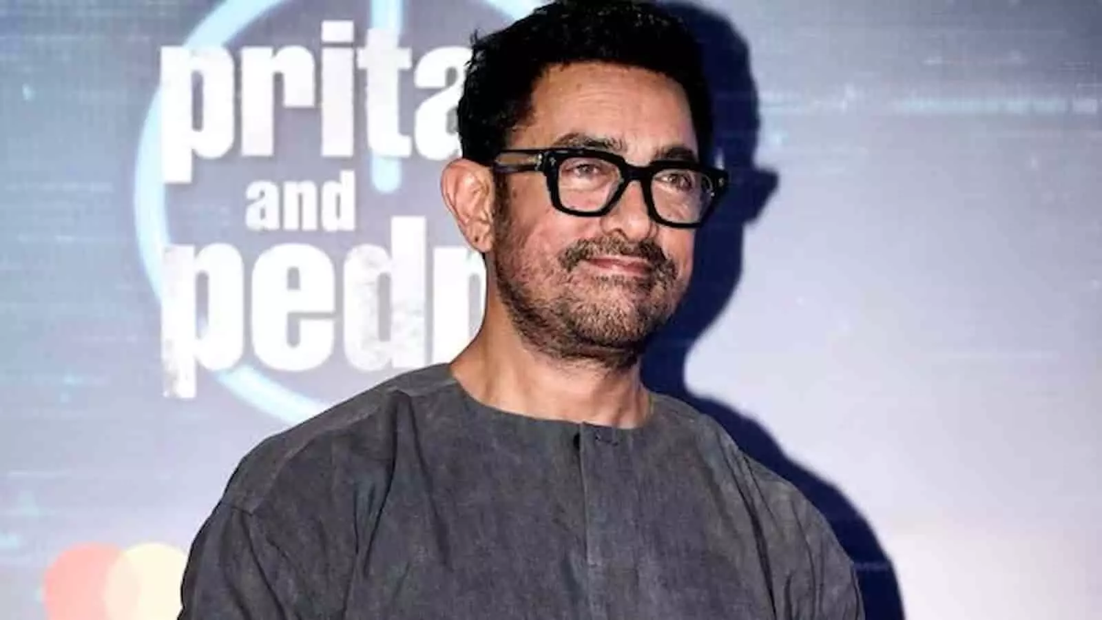 तस्वीर में अभिनेता आमिर खान चश्मा पहने हुए इवेंट में खड़े नजर आ रहे हैं। तस्वीर में अभिनेता आमिर खान चश्मा पहने हुए इवेंट में खड़े नजर आ रहे हैं।