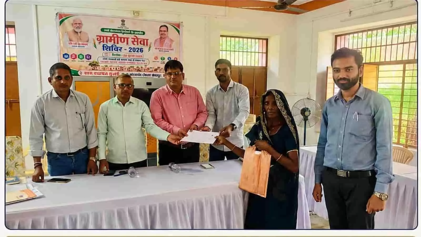 ग्राम पंचायत भवन में अधिकारी एक महिला को सामाजिक सुरक्षा पेंशन दस्तावेज प्रदान करते हुए। ग्राम पंचायत भवन में अधिकारी एक महिला को सामाजिक सुरक्षा पेंशन दस्तावेज प्रदान करते हुए।