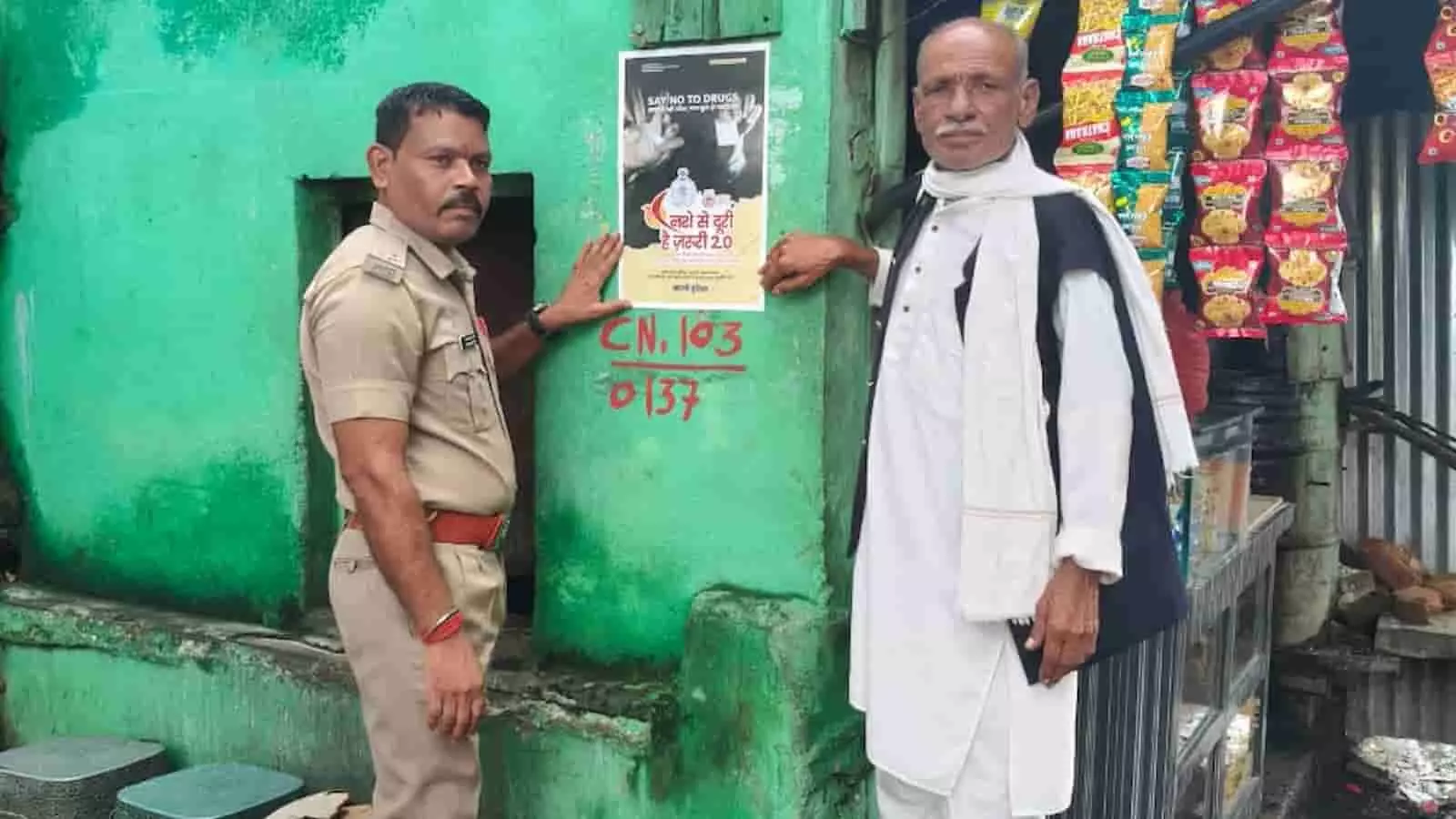 तस्वीर में पुलिसकर्मी और बुजुर्ग व्यक्ति चाय-पान की दुकान पर नशामुक्ति पोस्टर लगाते दिख रहे हैं। तस्वीर में पुलिसकर्मी और बुजुर्ग व्यक्ति चाय-पान की दुकान पर नशामुक्ति पोस्टर लगाते दिख रहे हैं।