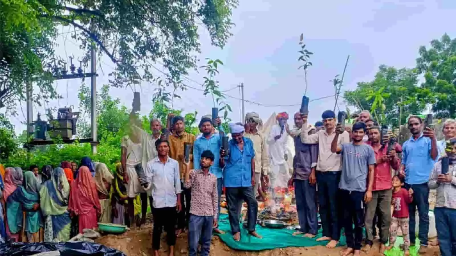 तस्वीर में मानपुरा गांव के ग्रामीण और शिक्षक हाथों में पौधे लिए हुए खड़े हैं। तस्वीर में मानपुरा गांव के ग्रामीण और शिक्षक हाथों में पौधे लिए हुए खड़े हैं।