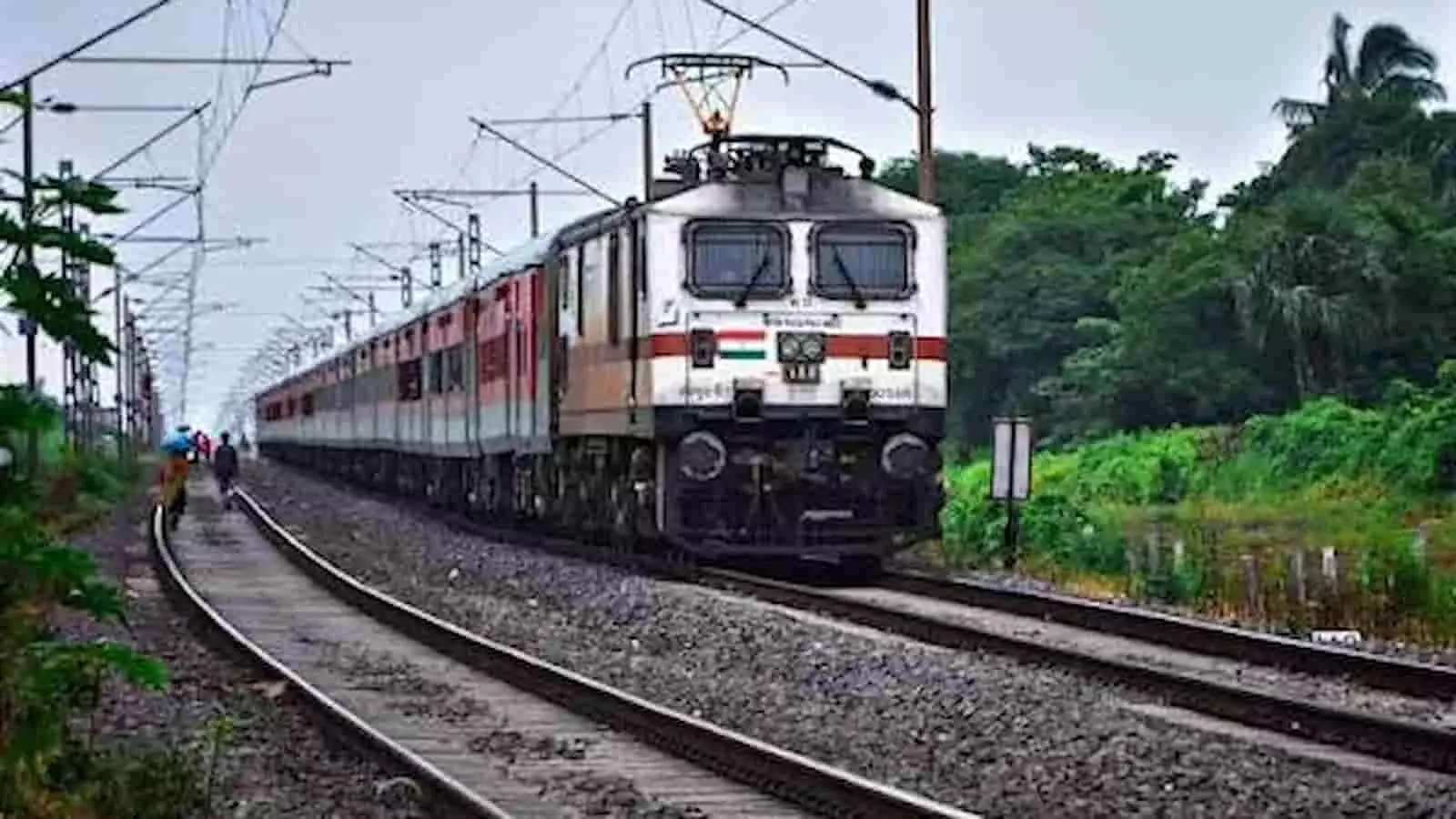 पटरियों पर चलती हुई एक्सप्रेस ट्रेन की तस्वीर।