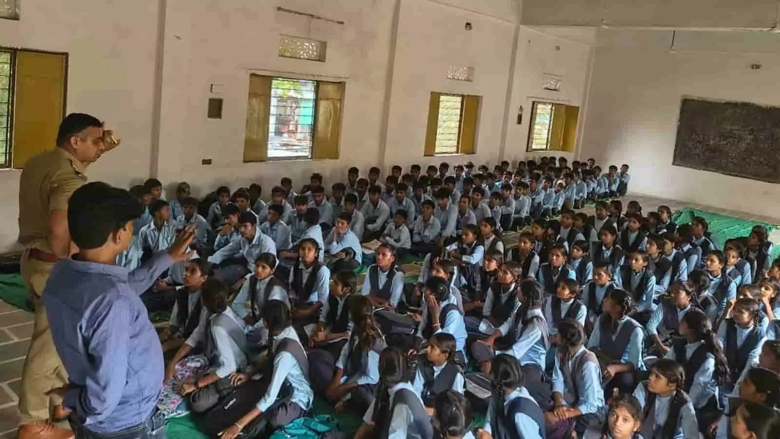 तस्वीर में पुलिस अधिकारी कक्षा में बैठे विद्यार्थियों को संबोधित करते हुए दिख रहे हैं। तस्वीर में पुलिस अधिकारी कक्षा में बैठे विद्यार्थियों को संबोधित करते हुए दिख रहे हैं।