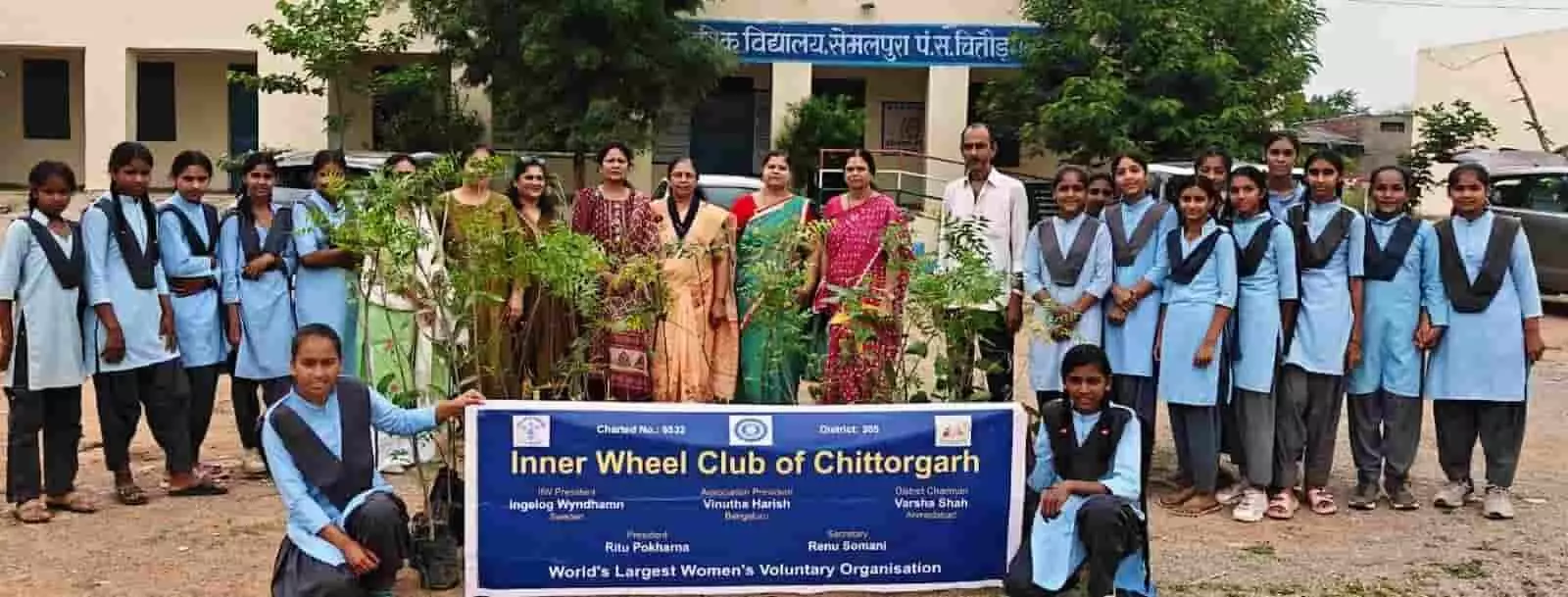 तस्वीर में सेमलपुरा विद्यालय परिसर में पौधे और बैनर लिए खड़ी छात्राएं व इनर व्हील क्लब की सदस्य।