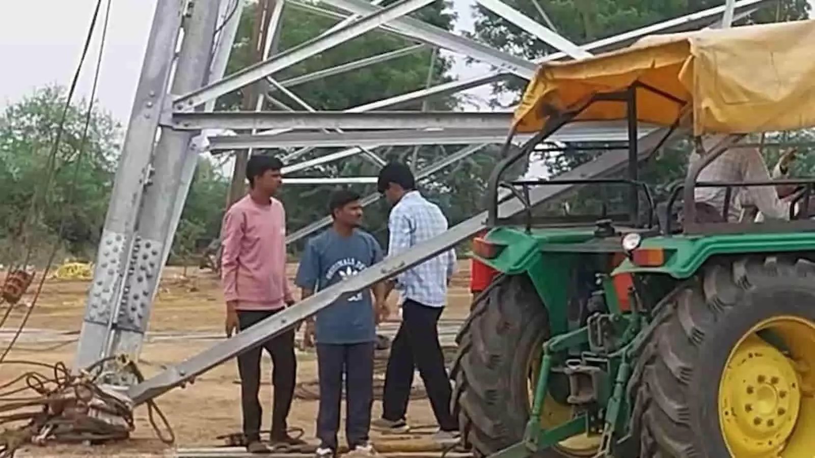 तस्वीर में सिरोही में दुर्घटनास्थल पर गिरा हुआ बिजली टावर और खड़े लोग दिख रहे हैं।