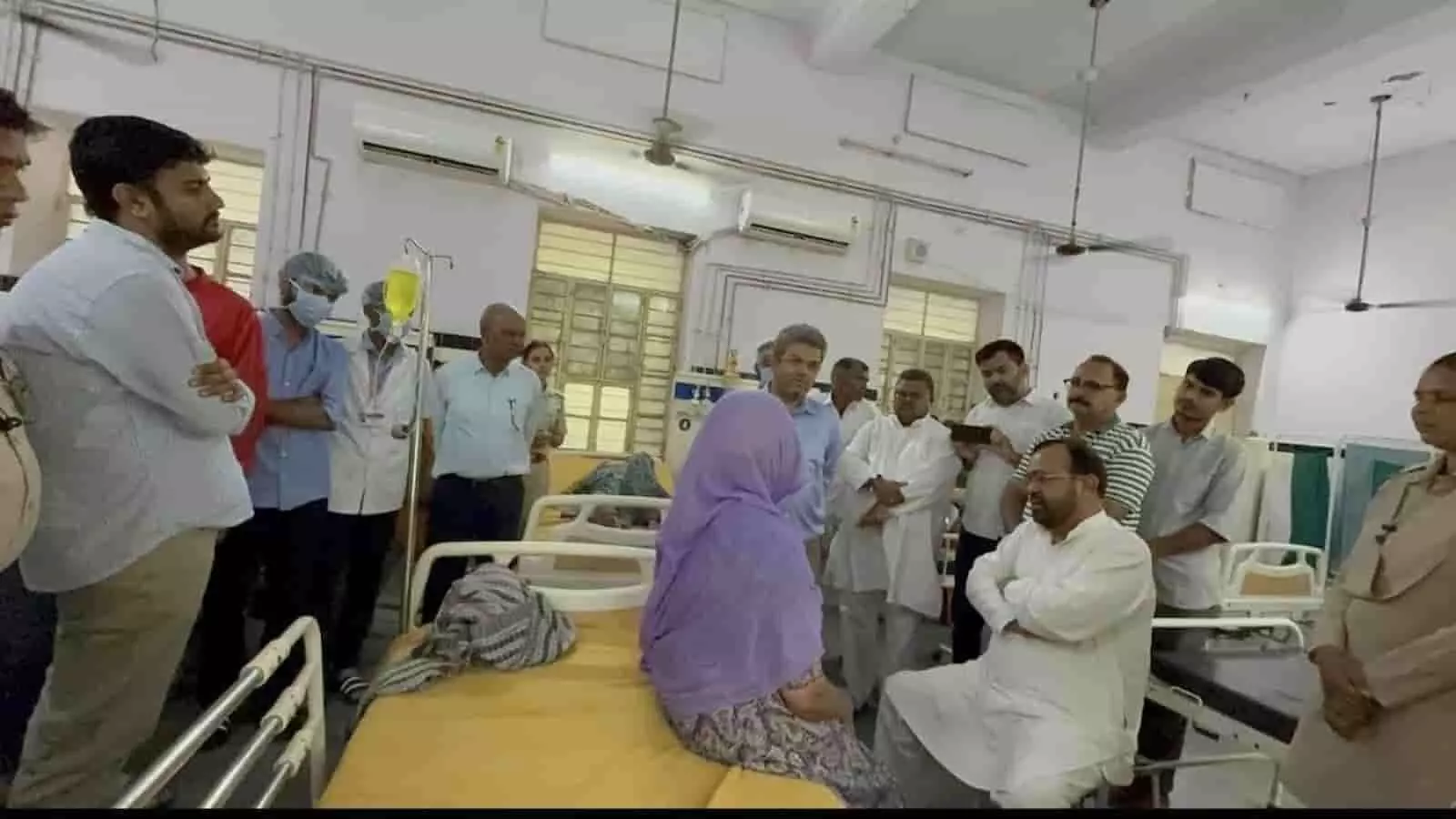 तस्वीर में अस्पताल के वार्ड में बेड पर बैठी बुजुर्ग महिला से बातचीत करते संयम लोढ़ा और अन्य लोग।