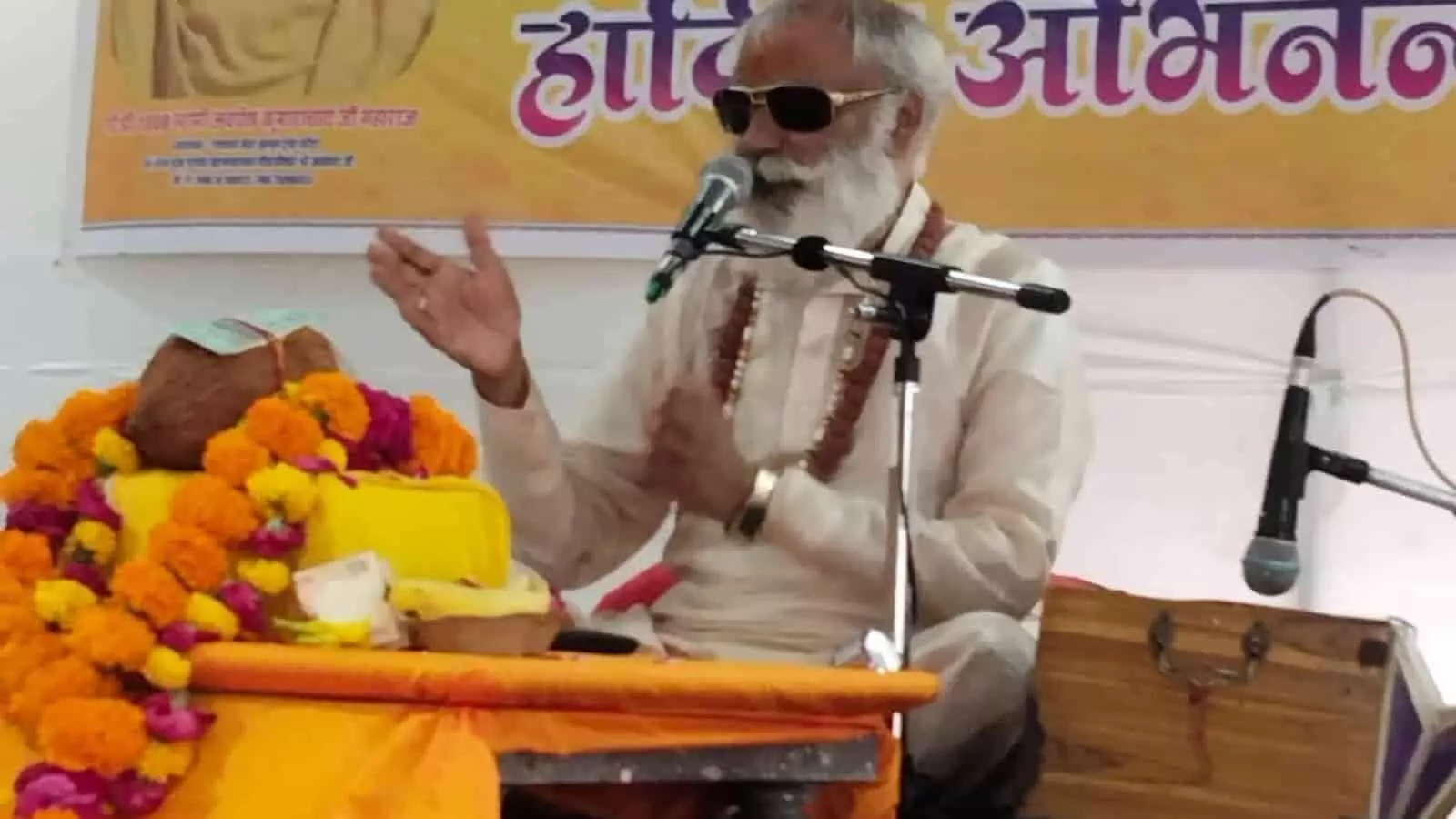 तस्वीर में मंच पर डॉ. राजेश मिश्रा प्रवचन देते हुए श्री रामधाम सेवा आश्रम कोटा में दिखाई दे रहे हैं।