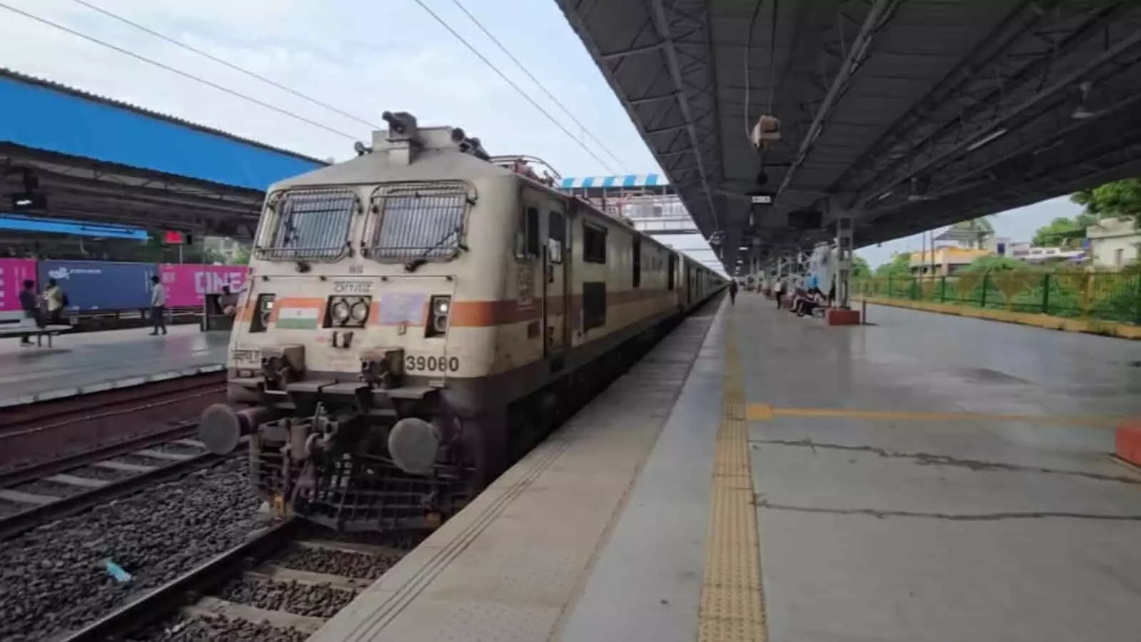 रेलवे स्टेशन पर प्लेटफॉर्म के पास ट्रैक पर खड़ी ट्रेन और यात्री। रेलवे स्टेशन पर प्लेटफॉर्म के पास ट्रैक पर खड़ी ट्रेन और यात्री।