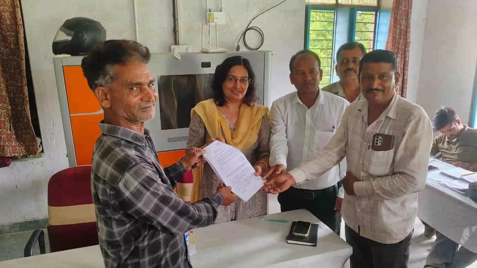 तस्वीर में ग्राम पंचायत कार्यालय अमरपुरा खालसा में अधिकारियों की मौजूदगी में दस्तावेज देखते लोग। तस्वीर में ग्राम पंचायत कार्यालय अमरपुरा खालसा में अधिकारियों की मौजूदगी में दस्तावेज देखते लोग।