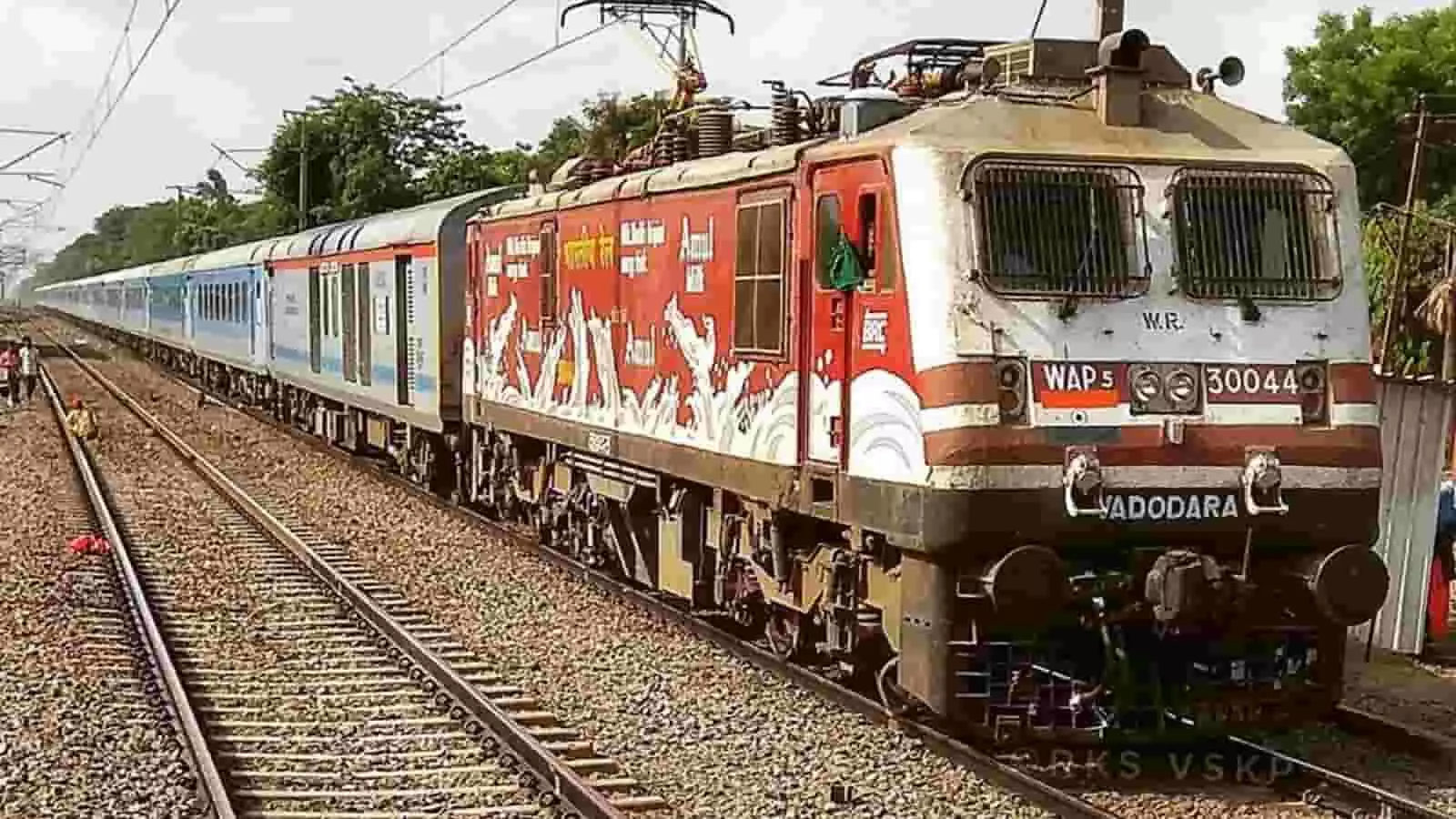 तस्वीर में रेलवे पटरी पर खड़ी एक ट्रेन और इलेक्ट्रिक इंजन दिखाई दे रहा है। तस्वीर में रेलवे पटरी पर खड़ी एक ट्रेन और इलेक्ट्रिक इंजन दिखाई दे रहा है।