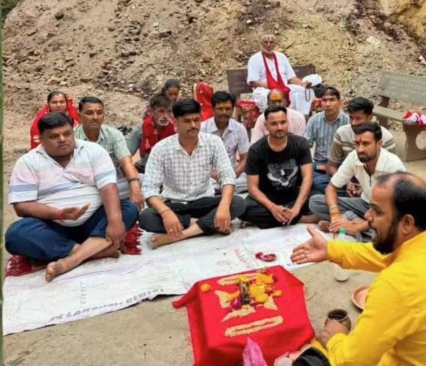 अरावली की पहाड़ियों में स्थित मंदिर परिसर में बैठकर धार्मिक अनुष्ठान करते हुए पुजारी और श्रद्धालु। अरावली की पहाड़ियों में स्थित मंदिर परिसर में बैठकर धार्मिक अनुष्ठान करते हुए पुजारी और श्रद्धालु।