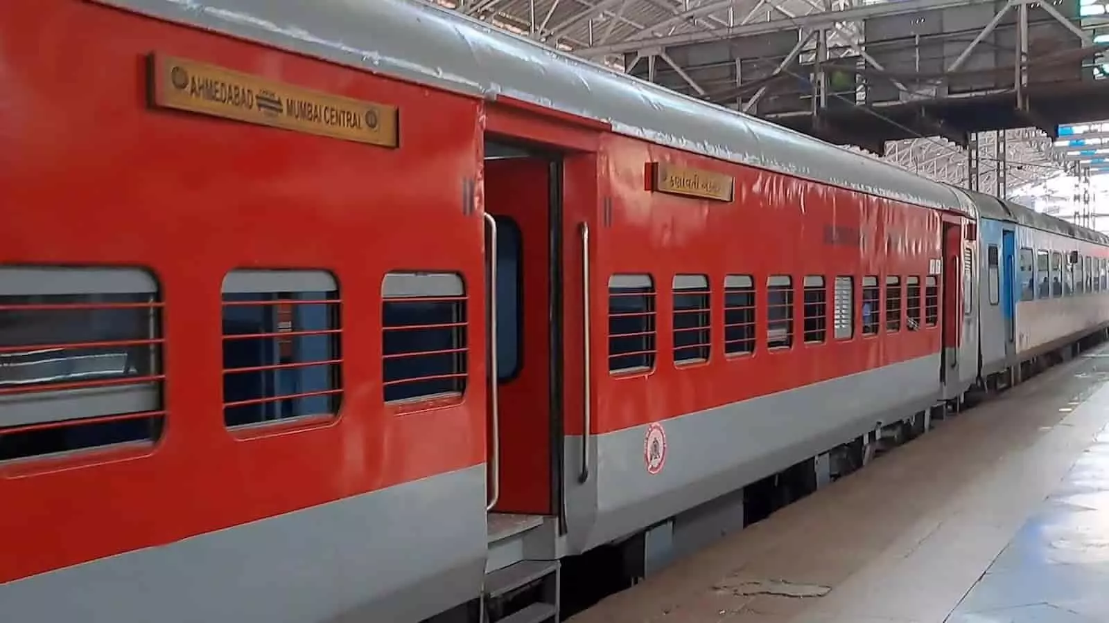 तस्वीर में रेलवे स्टेशन के प्लेटफॉर्म पर खड़ी ट्रेन और उसके पास चलते हुए व्यक्ति दिखाई दे रहे हैं। तस्वीर में रेलवे स्टेशन के प्लेटफॉर्म पर खड़ी ट्रेन और उसके पास चलते हुए व्यक्ति दिखाई दे रहे हैं।