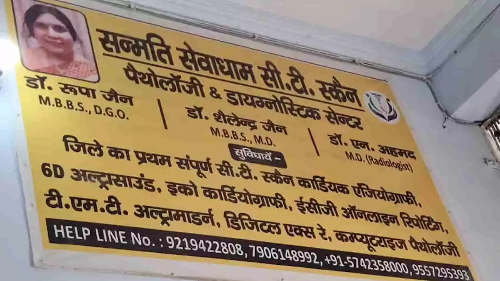 तस्वीर में एटा के सन्मति सेवा धाम सीटी स्कैन सेंटर का बोर्ड दिखाई दे रहा है।