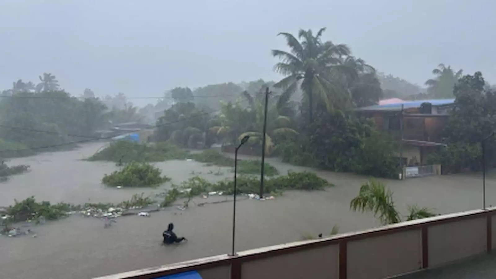 पालघर में भारी बारिश के कारण जलमग्न हुए इलाके और पानी में खड़े व्यक्ति का दृश्य। पालघर में भारी बारिश के कारण जलमग्न हुए इलाके और पानी में खड़े व्यक्ति का दृश्य।