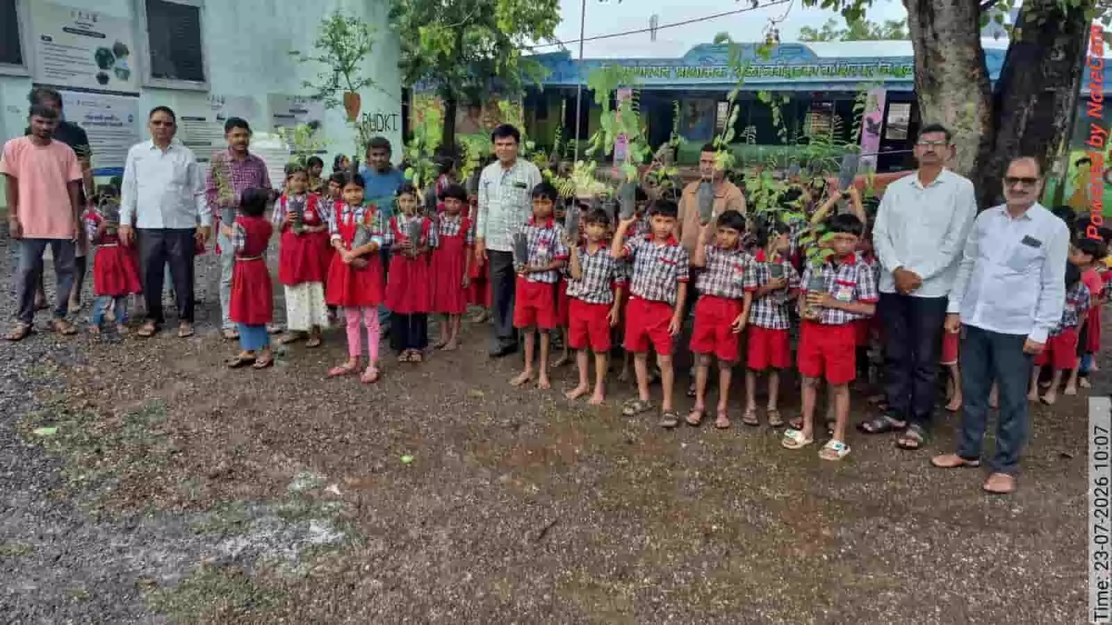 तस्वीर में स्कूल परिसर में हाथों में पौधे लिए छात्र और शिक्षक खड़े दिखाई दे रहे हैं। तस्वीर में स्कूल परिसर में हाथों में पौधे लिए छात्र और शिक्षक खड़े दिखाई दे रहे हैं।