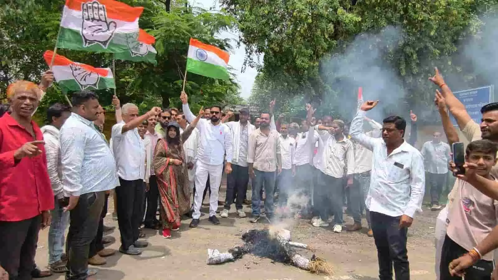 तस्वीर में सड़क पर जलते पुतले के पास तिरंगा और झंडे थामे प्रदर्शन करते कांग्रेस कार्यकर्ता। तस्वीर में सड़क पर जलते पुतले के पास तिरंगा और झंडे थामे प्रदर्शन करते कांग्रेस कार्यकर्ता।