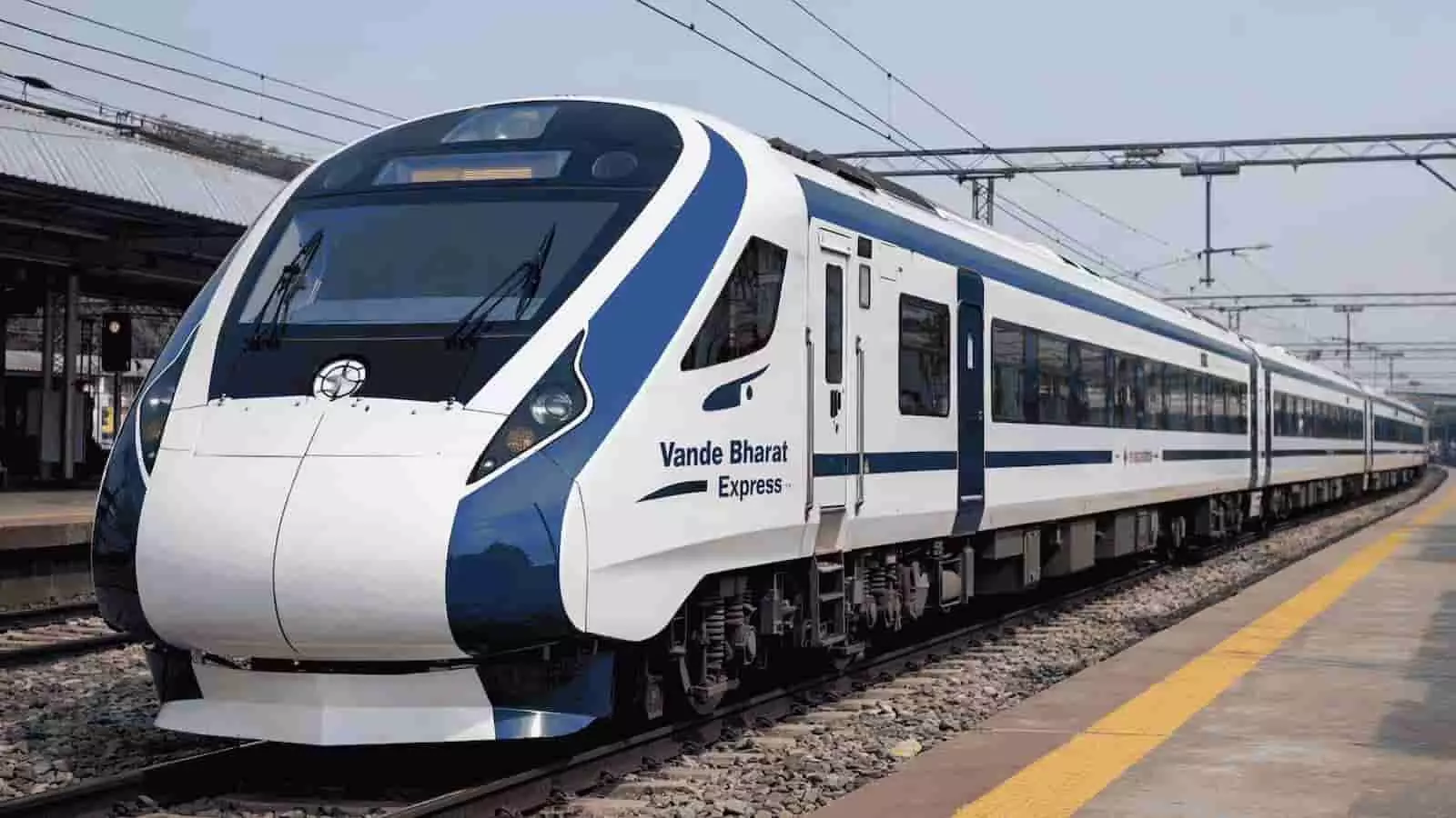 तस्वीर में रेलवे स्टेशन पर पटरी पर खड़ी वंदे भारत एक्सप्रेस ट्रेन दिखाई दे रही है। तस्वीर में रेलवे स्टेशन पर पटरी पर खड़ी वंदे भारत एक्सप्रेस ट्रेन दिखाई दे रही है।