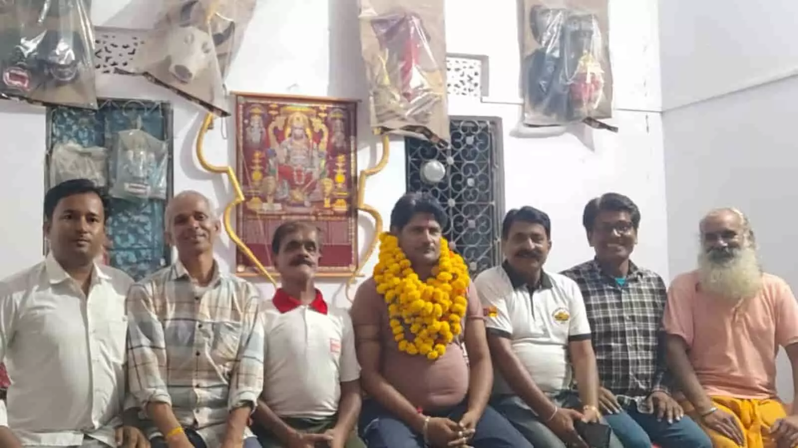 बौंली में श्री राम कला मंडल के नवनिर्वाचित अध्यक्ष राघवेश शर्मा माला पहने अन्य सदस्यों के साथ बैठे हैं।