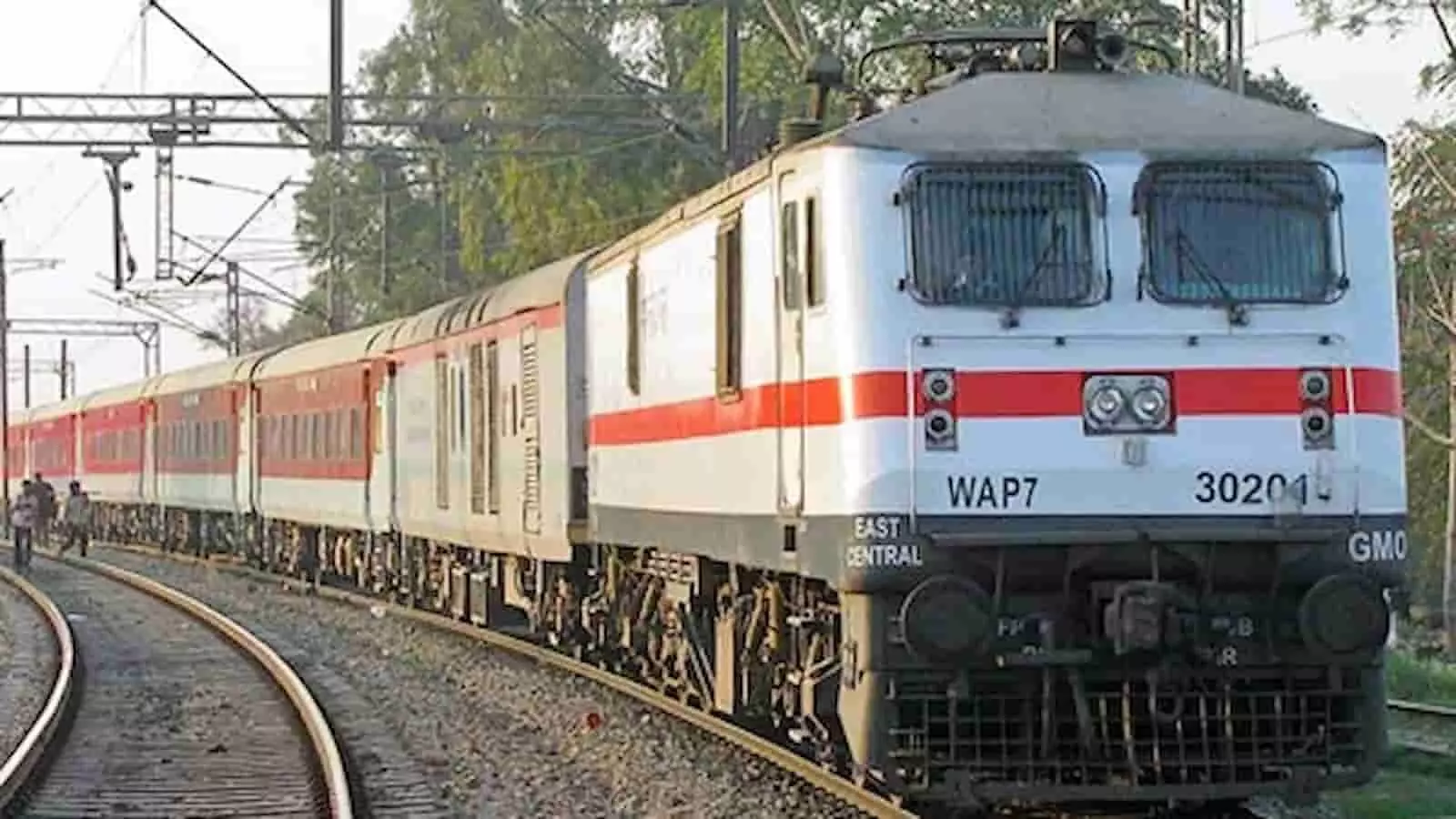 तस्वीर में रेलवे ट्रैक पर खड़ी ट्रेन और उसका इंजन दिखाई दे रहा है। तस्वीर में रेलवे ट्रैक पर खड़ी ट्रेन और उसका इंजन दिखाई दे रहा है।