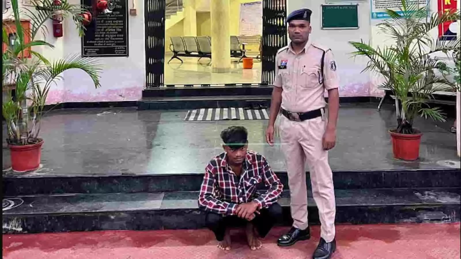 पुलिस स्टेशन परिसर के बाहर वर्दी में खड़े पुलिसकर्मी और फर्श पर बैठा गिरफ्तार आरोपी व्यक्ति। पुलिस स्टेशन परिसर के बाहर वर्दी में खड़े पुलिसकर्मी और फर्श पर बैठा गिरफ्तार आरोपी व्यक्ति।