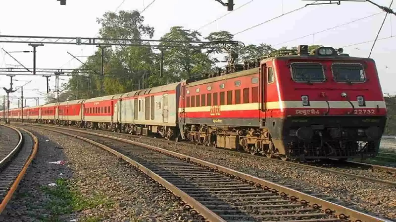 तस्वीर में रेल पटरी पर चलती हुई लाल और ग्रे रंग की ट्रेन दिख रही है। तस्वीर में रेल पटरी पर चलती हुई लाल और ग्रे रंग की ट्रेन दिख रही है।