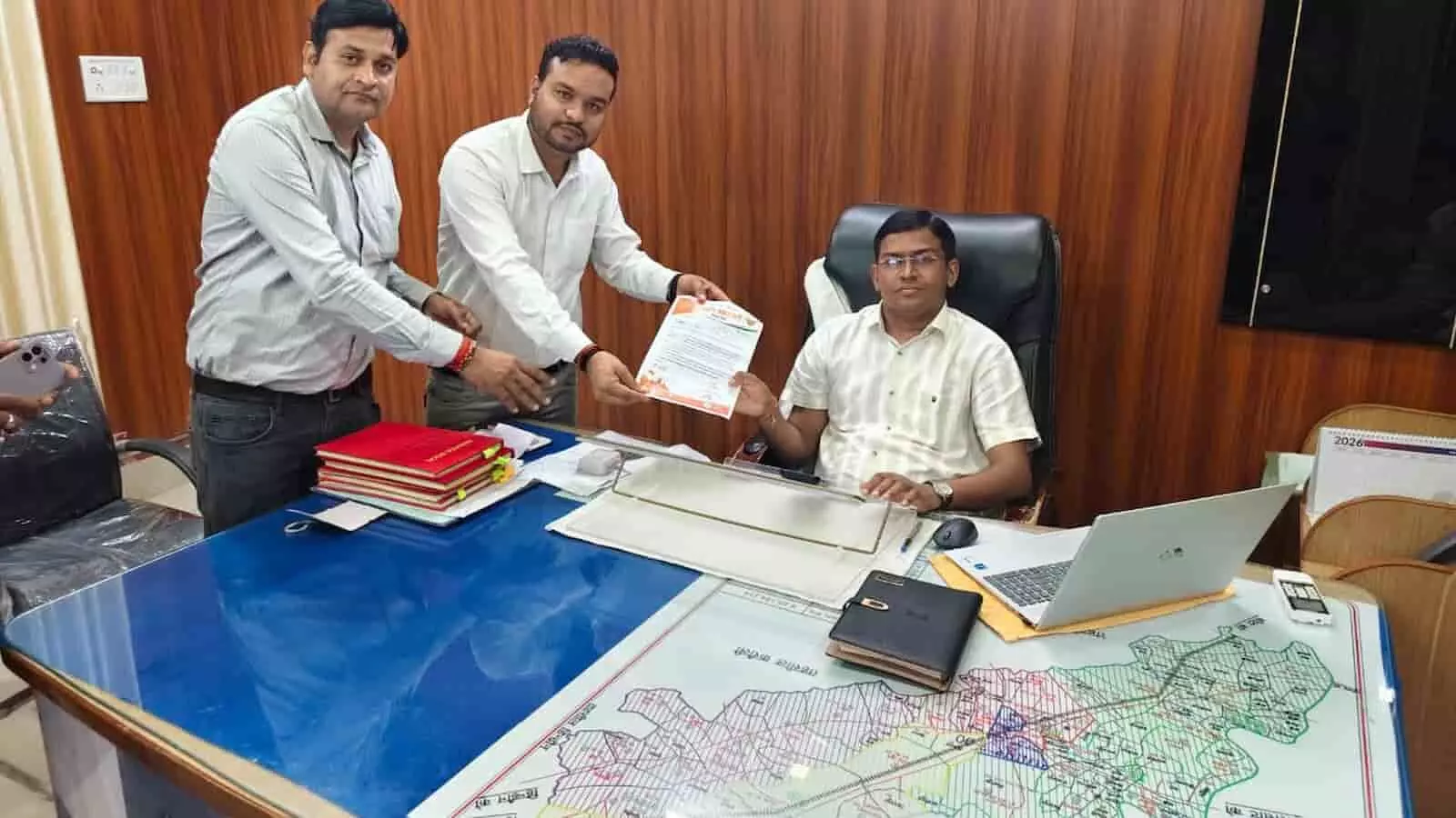 तस्वीर में उप जिला कलेक्टर को सड़क निर्माण की मांग का ज्ञापन सौंपते लोग।