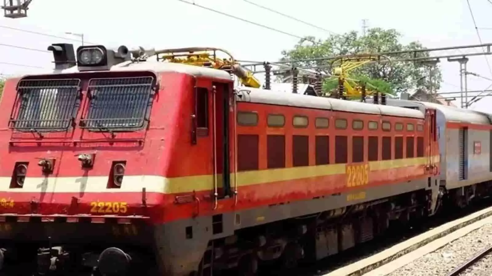 तस्वीर में रेलवे ट्रैक पर खड़ी एक लाल रंग की ट्रेन दिख रही है। तस्वीर में रेलवे ट्रैक पर खड़ी एक लाल रंग की ट्रेन दिख रही है।