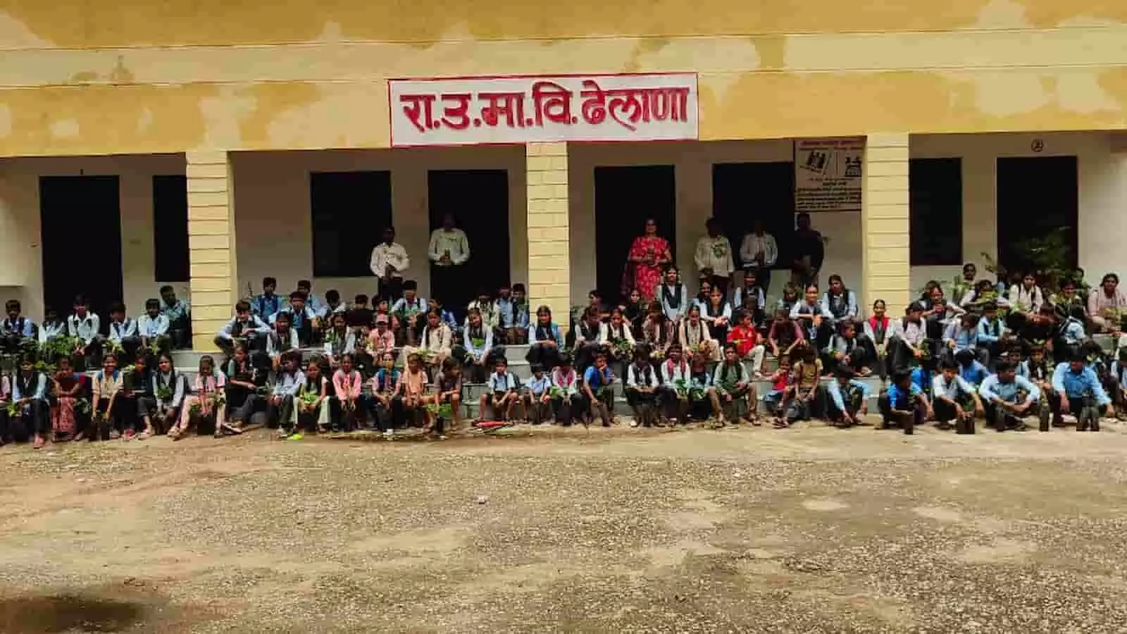 ढेलाणा के सरकारी स्कूल में हाथों में पौधे लिए बैठे विद्यार्थी और शिक्षक। ढेलाणा के सरकारी स्कूल में हाथों में पौधे लिए बैठे विद्यार्थी और शिक्षक।
