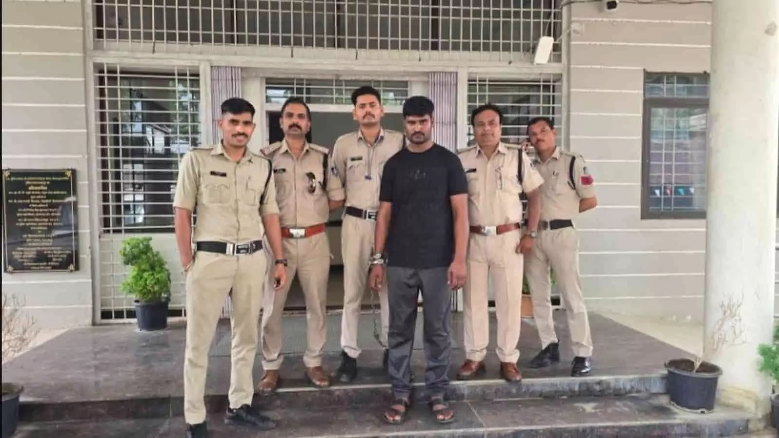 थाना परिसर के बाहर हथकड़ी लगे आरोपी के साथ खड़े शाहपुर थाने के पुलिसकर्मी। थाना परिसर के बाहर हथकड़ी लगे आरोपी के साथ खड़े शाहपुर थाने के पुलिसकर्मी।