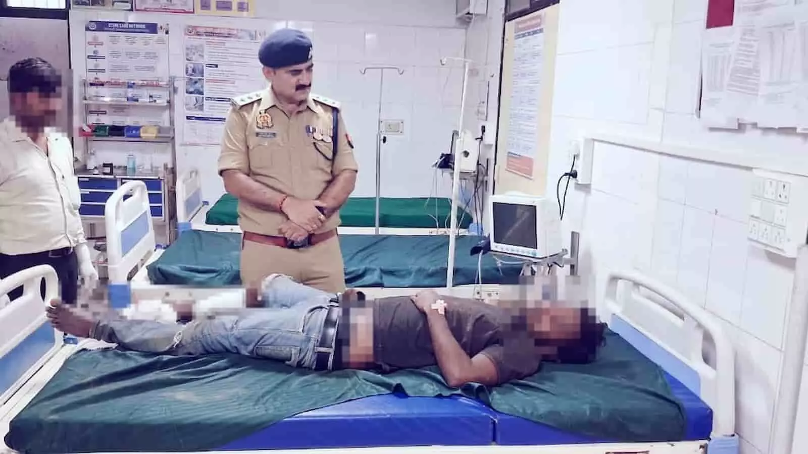 अस्पताल के बिस्तर पर लेटे घायल व्यक्ति की निगरानी करते पुलिस अधिकारी की तस्वीर। अस्पताल के बिस्तर पर लेटे घायल व्यक्ति की निगरानी करते पुलिस अधिकारी की तस्वीर।