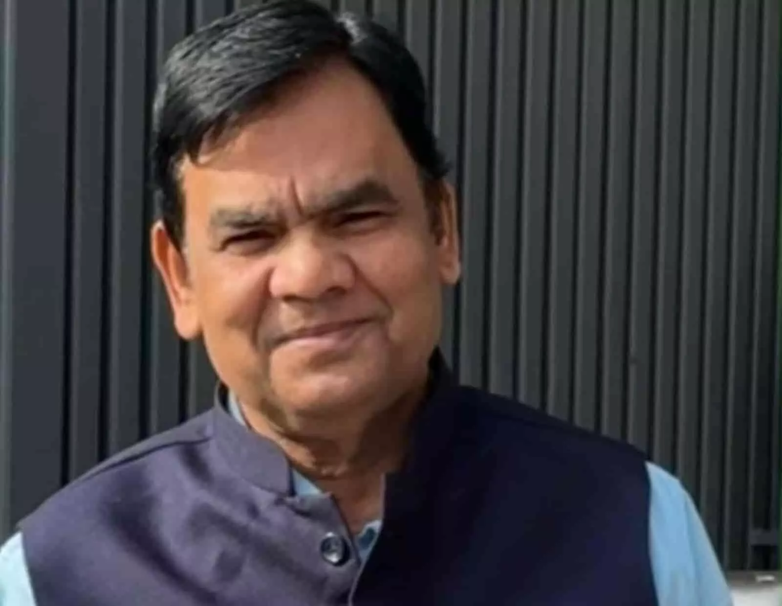 तस्वीर में एक व्यक्ति नीले रंग की शर्ट और जैकेट पहने हुए दिखाई दे रहा है। तस्वीर में एक व्यक्ति नीले रंग की शर्ट और जैकेट पहने हुए दिखाई दे रहा है।