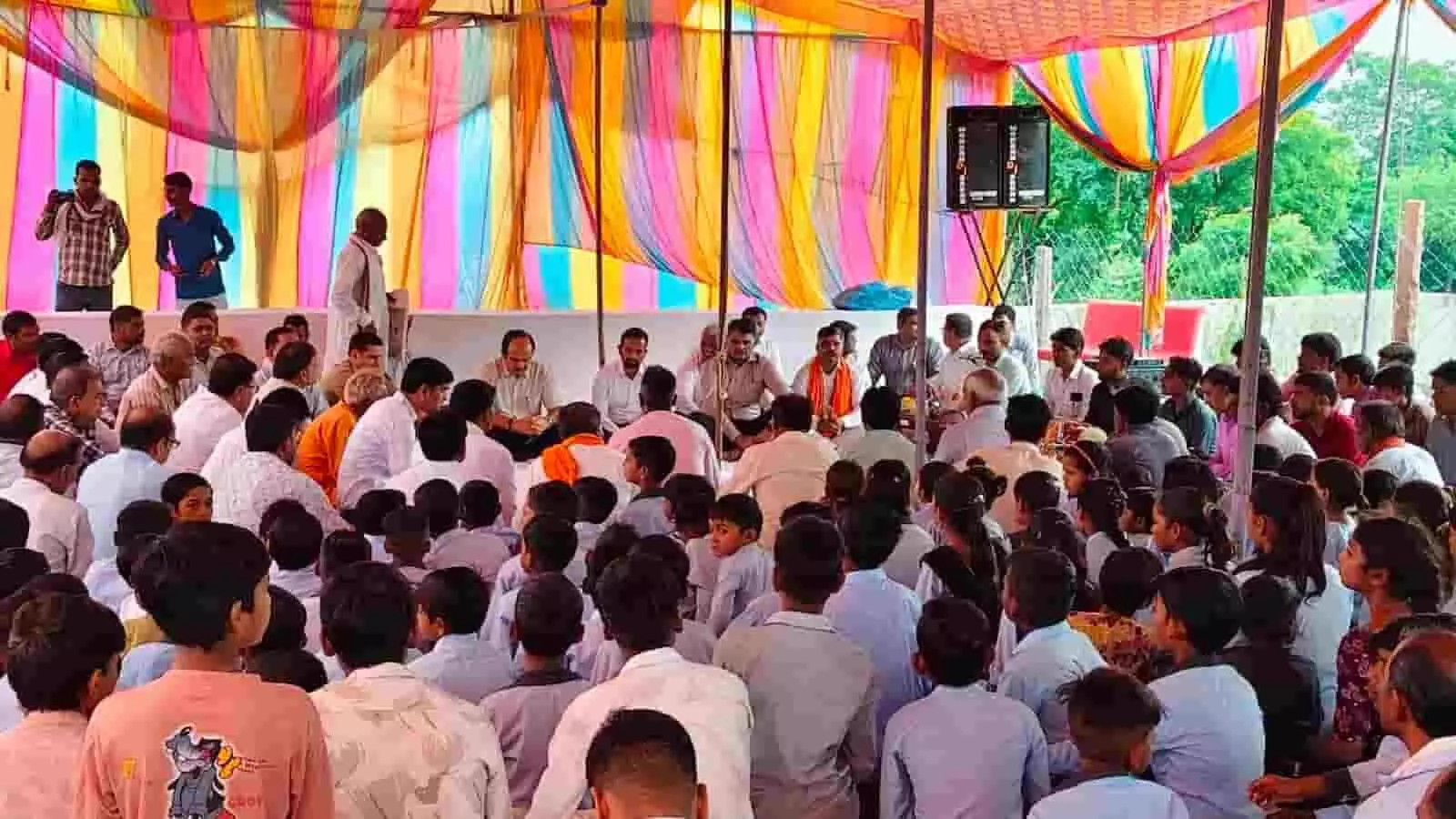 तस्वीर में मंडप के नीचे मंच पर बैठे अधिकारी और सामने बैठे छात्र श्रद्धांजलि सभा में शामिल हैं। तस्वीर में मंडप के नीचे मंच पर बैठे अधिकारी और सामने बैठे छात्र श्रद्धांजलि सभा में शामिल हैं।