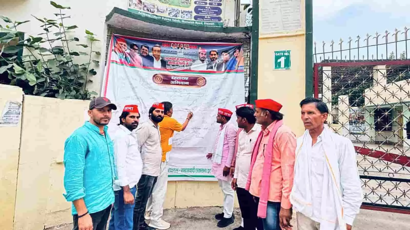 इटावा में कॉलेज गेट के पास बैनर पर हस्ताक्षर करते समाजवादी छात्रसभा कार्यकर्ता।