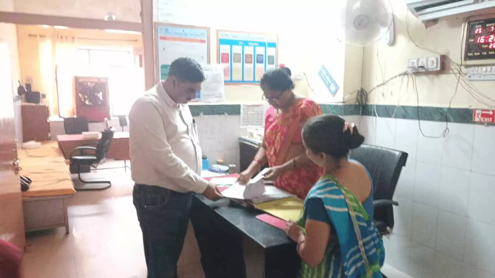 तस्वीर में करौली जिला अस्पताल की हेल्प डेस्क पर अधिकारी दस्तावेजों की जांच कर रहे हैं।