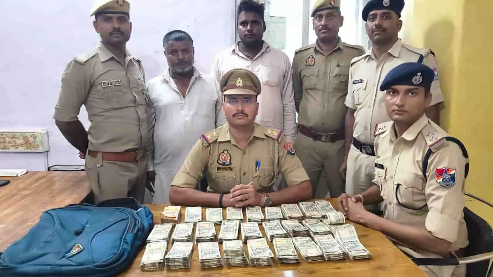 मेज पर रखी नकदी और बैग के साथ जीआरपी-आरपीएफ अधिकारी और पकड़े गए दो संदिग्ध व्यक्ति। मेज पर रखी नकदी और बैग के साथ जीआरपी-आरपीएफ अधिकारी और पकड़े गए दो संदिग्ध व्यक्ति।
