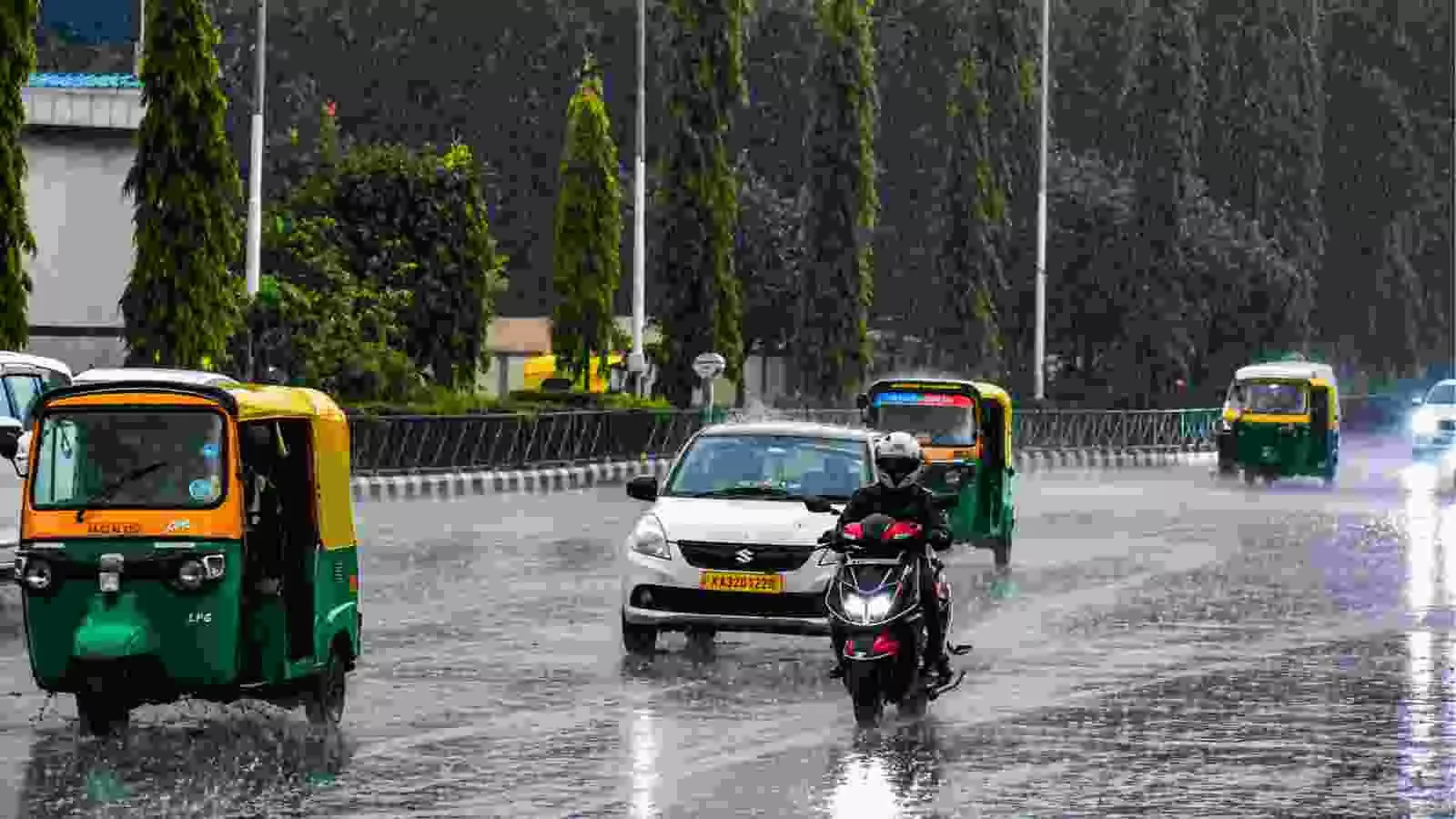 सड़क पर वाहन चलते हुए और बारिश होती हुई दक्षिण भारत में मानसून सक्रियता के दौरान।
