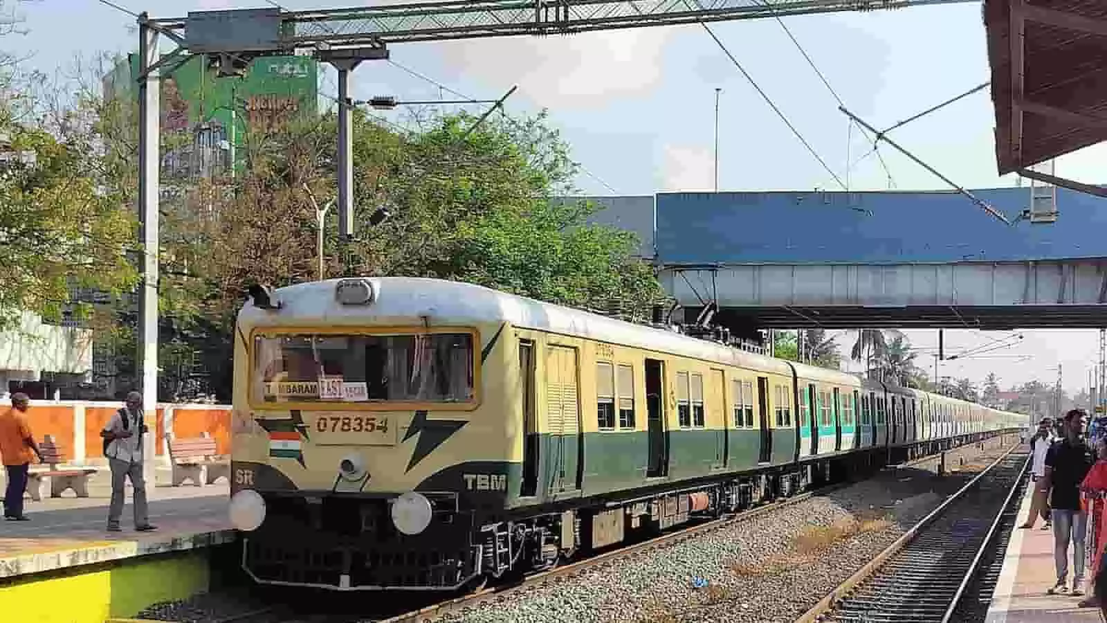 रेलवे स्टेशन के प्लेटफॉर्म पर खड़ी एक ट्रेन और पास में मौजूद यात्री।