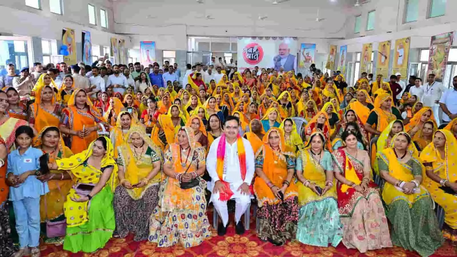 मुख्यमंत्री भजनलाल शर्मा सांगानेर में आदिवासी महिलाओं के साथ मन की बात सुनते हुए।