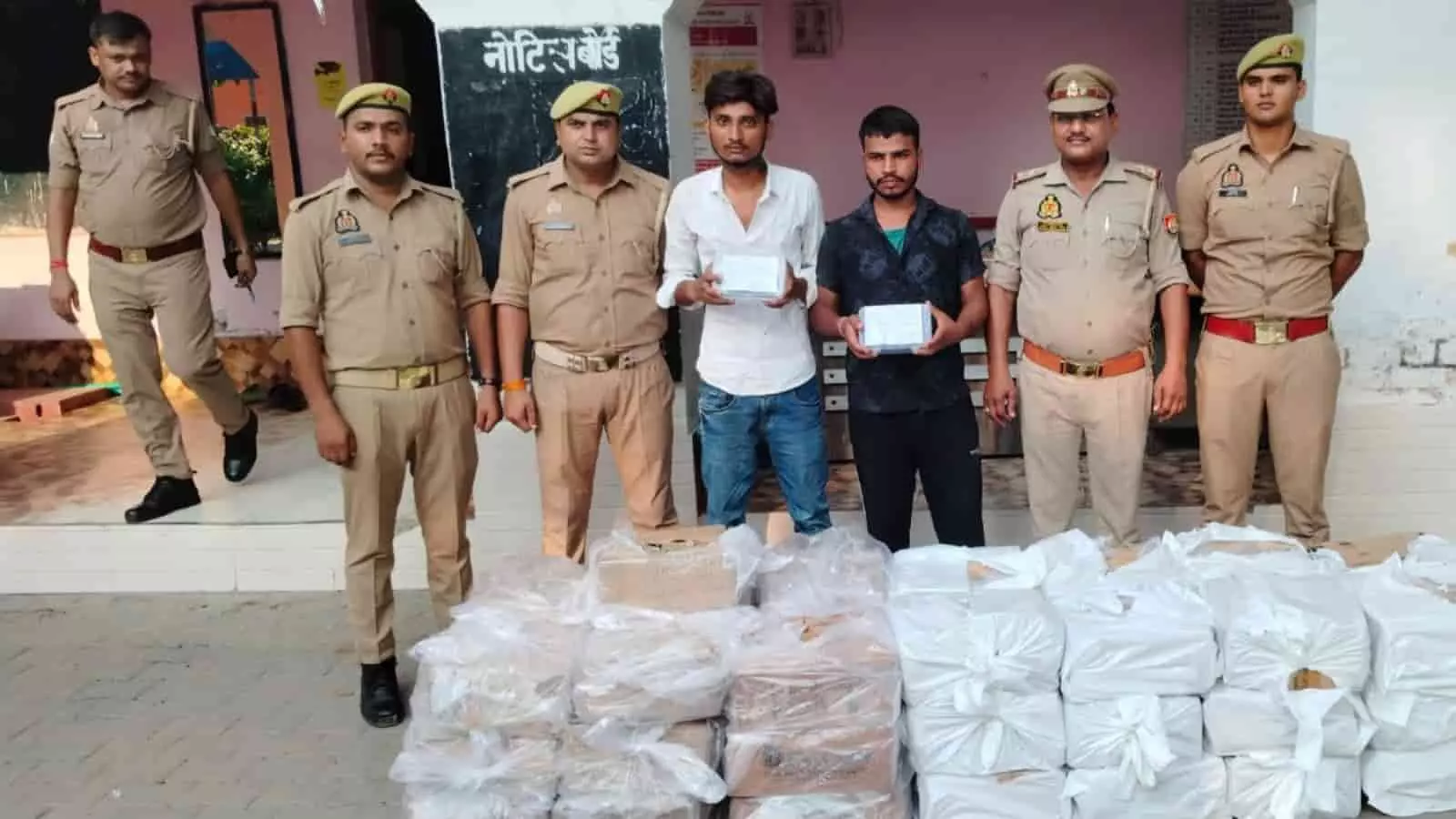 पुलिस स्टेशन के बाहर जब्त शराब के पैकेटों के साथ खड़े पुलिसकर्मी और आरोपी। पुलिस स्टेशन के बाहर जब्त शराब के पैकेटों के साथ खड़े पुलिसकर्मी और आरोपी।