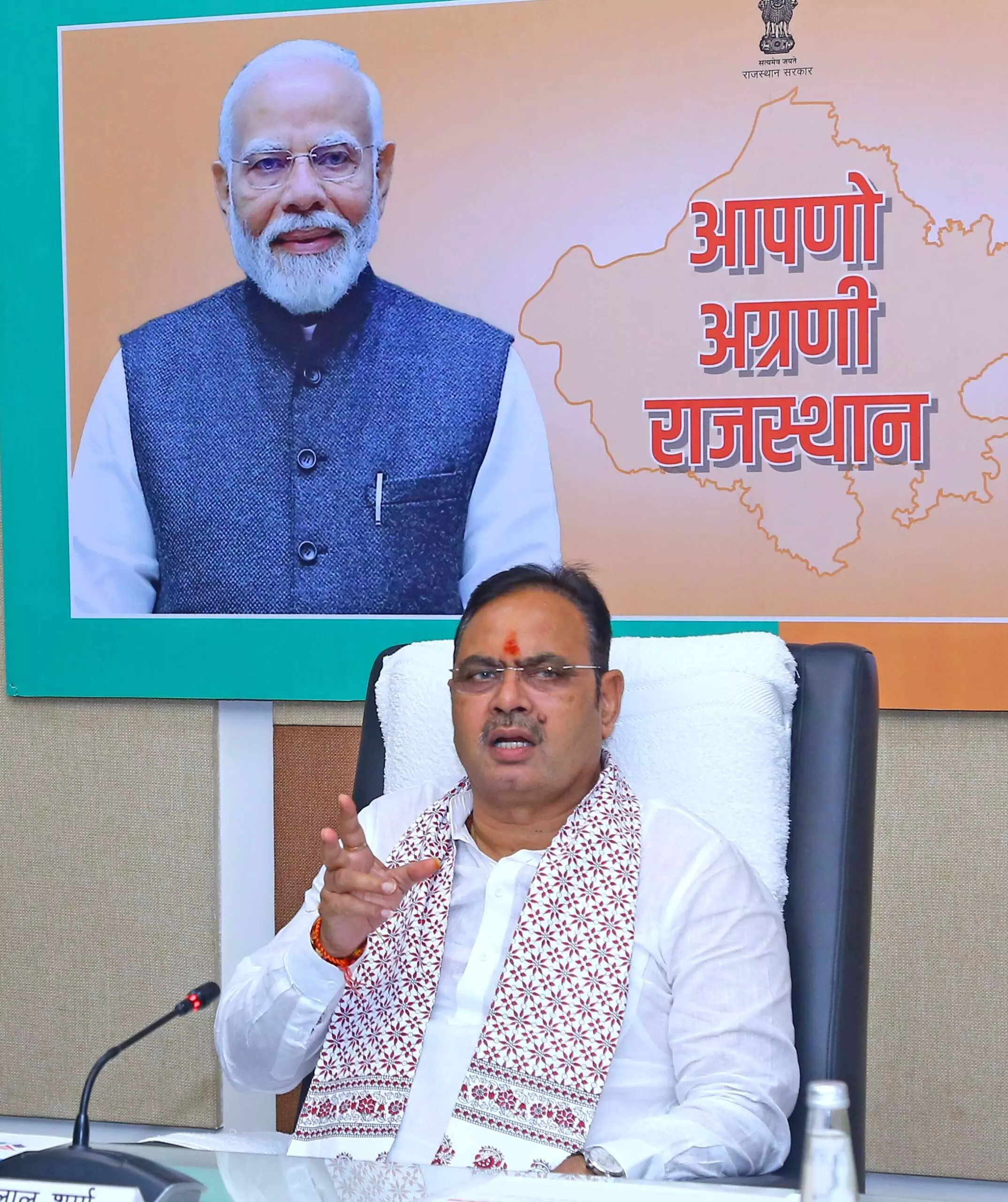 मुख्यमंत्री भजनलाल शर्मा बैठक में बोलते हुए नजर आ रहे हैं और पीछे पोस्टर लगा है। मुख्यमंत्री भजनलाल शर्मा बैठक में बोलते हुए नजर आ रहे हैं और पीछे पोस्टर लगा है।