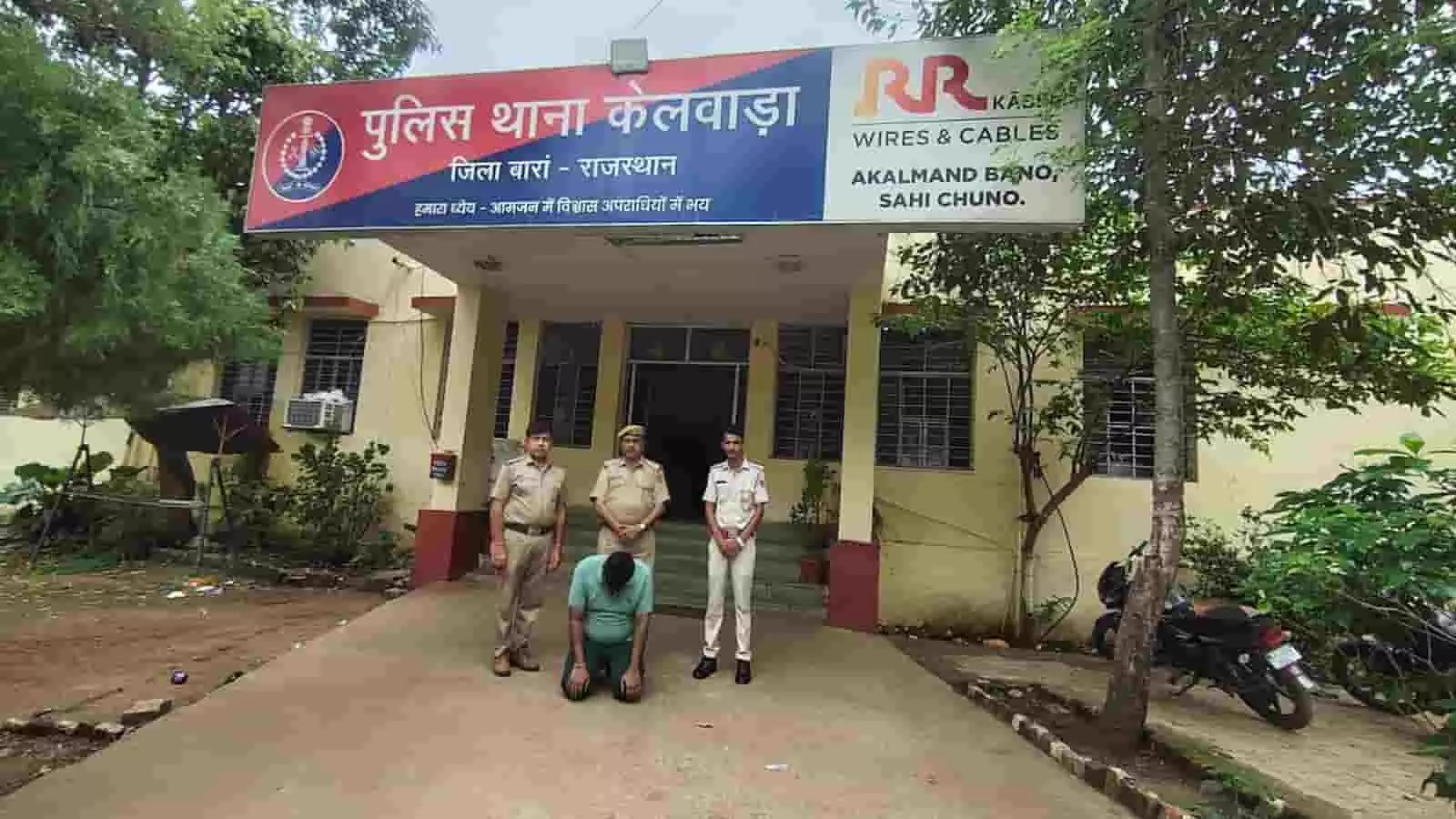 तस्वीर में केलवाड़ा पुलिस थाना परिसर के बाहर पुलिस अभिरक्षा में बैठा धोखाधड़ी का आरोपी दिख रहा है।