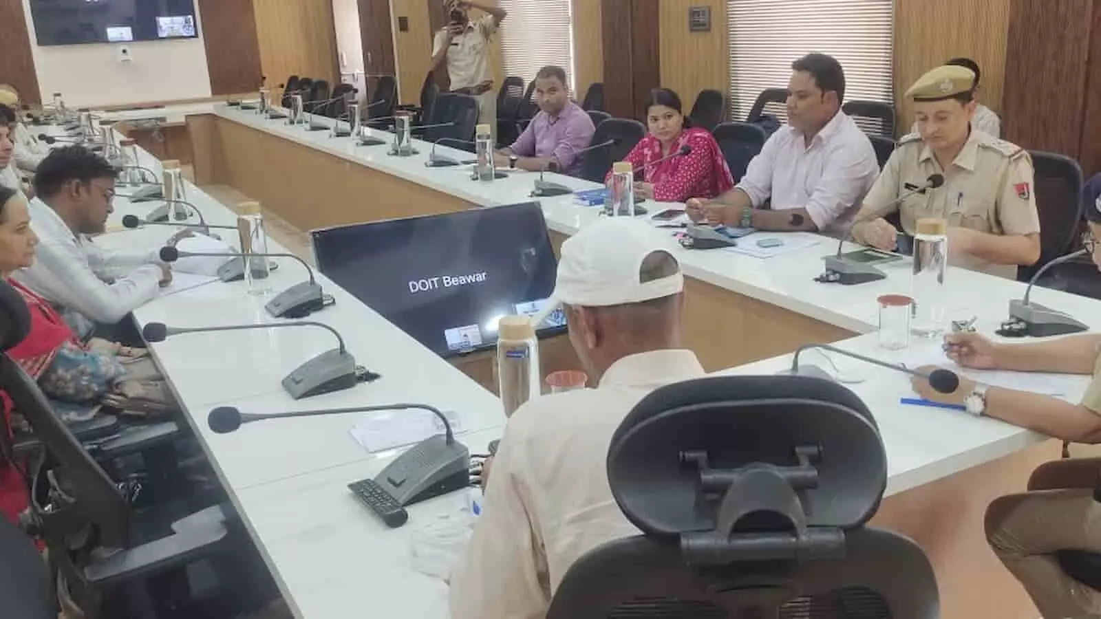 ब्यावर कलेक्ट्रेट सभागार में टेबल के चारों ओर बैठकर समीक्षा बैठक करते विभिन्न विभागों के अधिकारी।