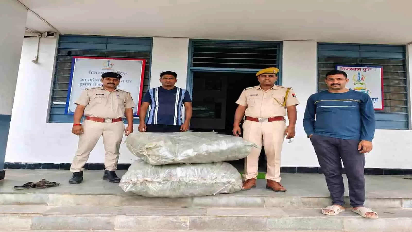 पुलिस स्टेशन के बाहर गांजे के दो कट्टों के साथ खड़े पुलिसकर्मी और दो व्यक्ति। पुलिस स्टेशन के बाहर गांजे के दो कट्टों के साथ खड़े पुलिसकर्मी और दो व्यक्ति।