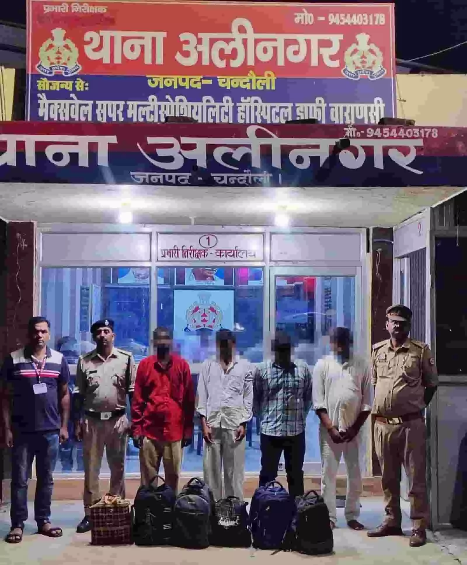 तस्वीर में अलीनगर थाने के बाहर पुलिस अधिकारी और चार अभियुक्त जब्त बैगों के साथ खड़े दिख रहे हैं।