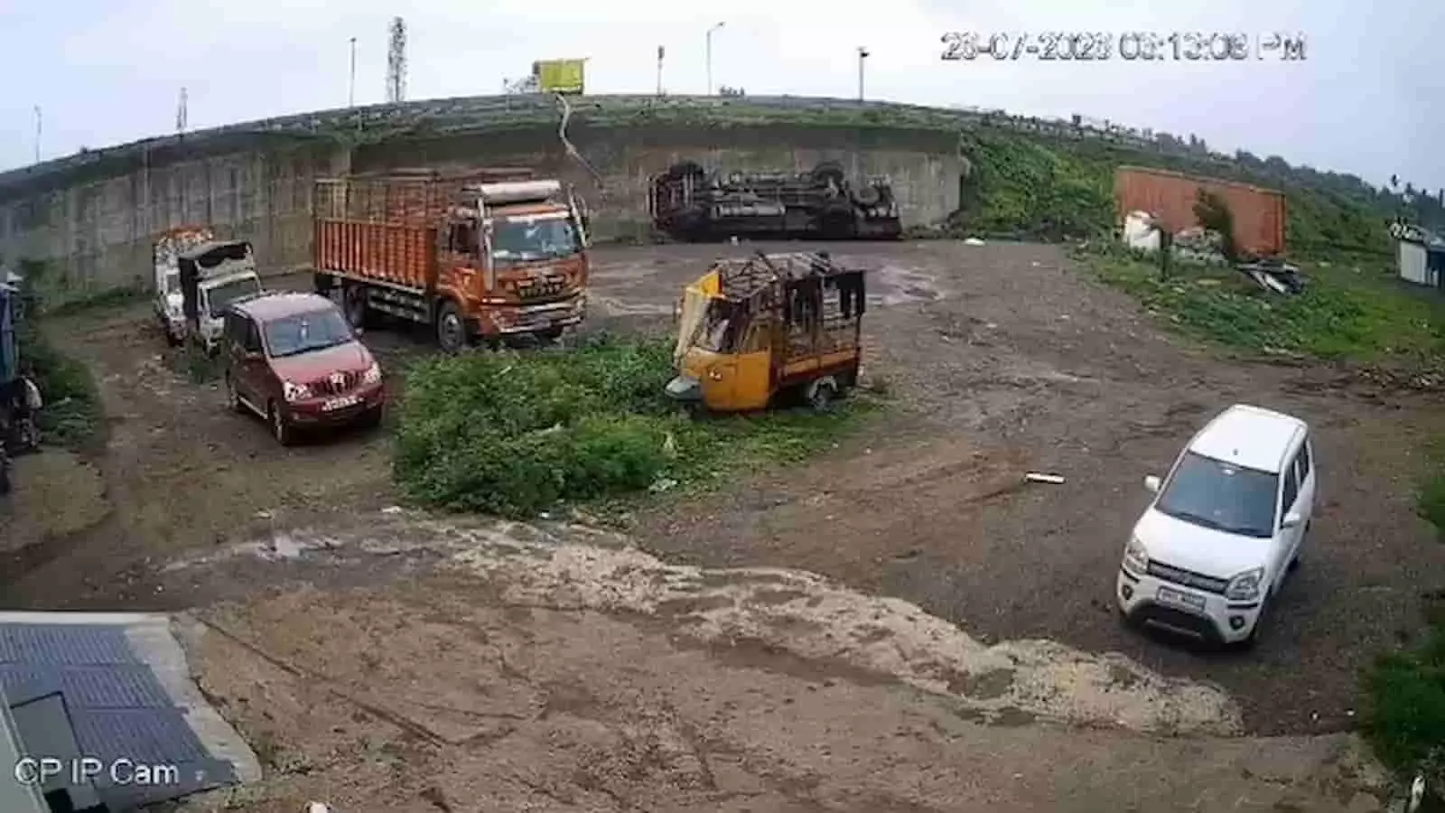 तस्वीर में पुल के नीचे गिरा एक ट्रक और आसपास अन्य वाहन दिखाई दे रहे हैं।