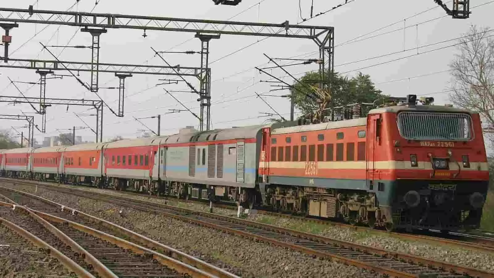 तस्वीर में पटरियों पर चलती हुई एक इलेक्ट्रिक लोकोमोटिव आधारित यात्री ट्रेन दिखाई दे रही है। तस्वीर में पटरियों पर चलती हुई एक इलेक्ट्रिक लोकोमोटिव आधारित यात्री ट्रेन दिखाई दे रही है।