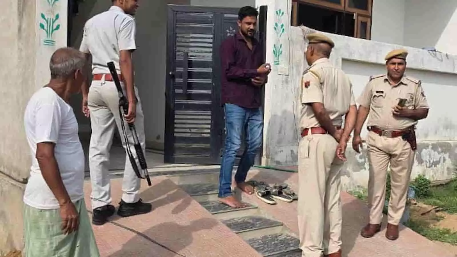 मकान के बाहर खड़े राजस्थान पुलिस कर्मी आरोपी व्यक्ति के खिलाफ कार्रवाई करते हुए।