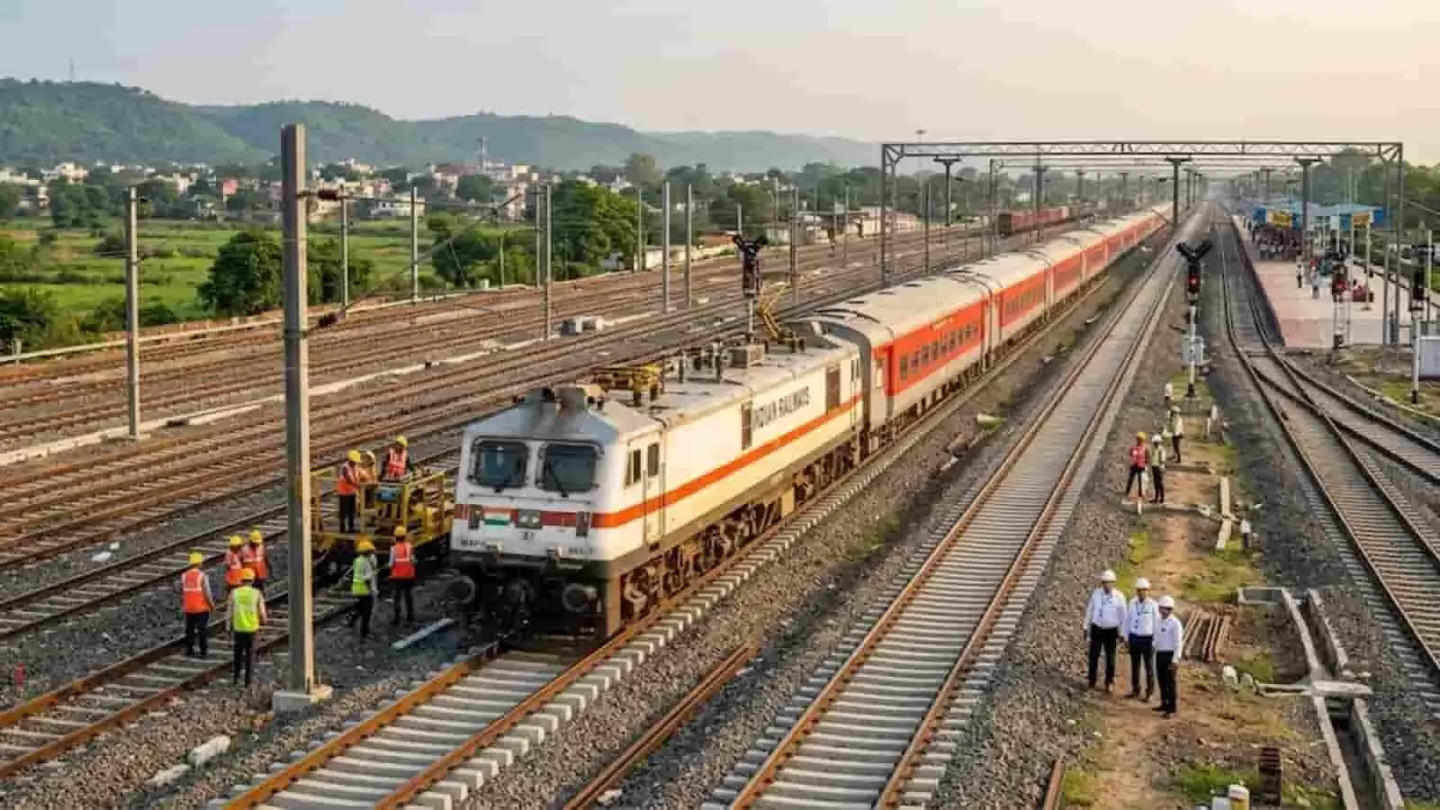 तस्वीर में रेलवे ट्रैक पर चलती एक्सप्रेस ट्रेन और पास में खड़े ट्रैक कर्मी दिख रहे हैं।