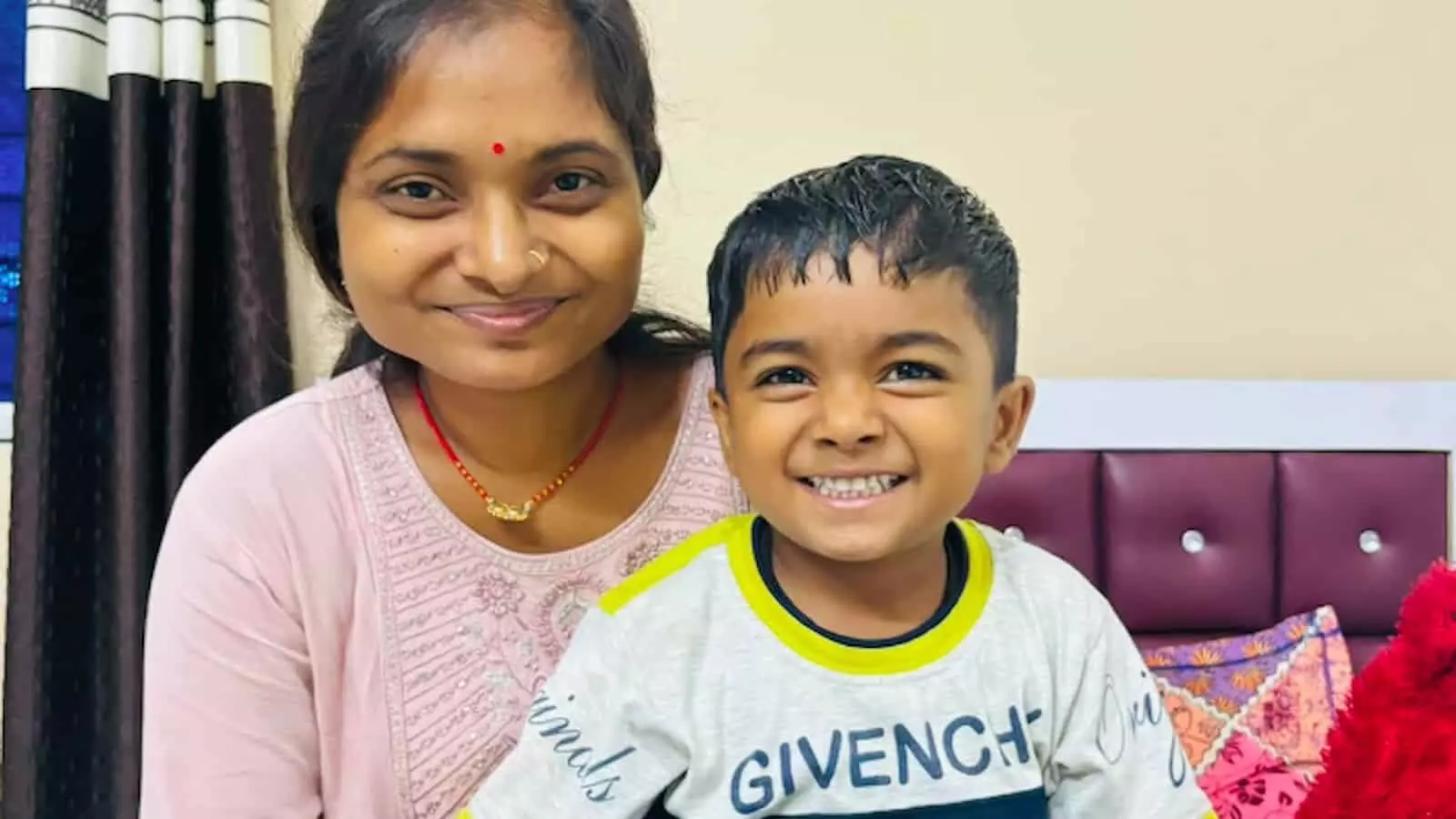 तस्वीर में महिला प्रियंका अग्रहरी और उनका बेटा कमरे में एक साथ मुस्कुराते हुए बैठे हैं। तस्वीर में महिला प्रियंका अग्रहरी और उनका बेटा कमरे में एक साथ मुस्कुराते हुए बैठे हैं।