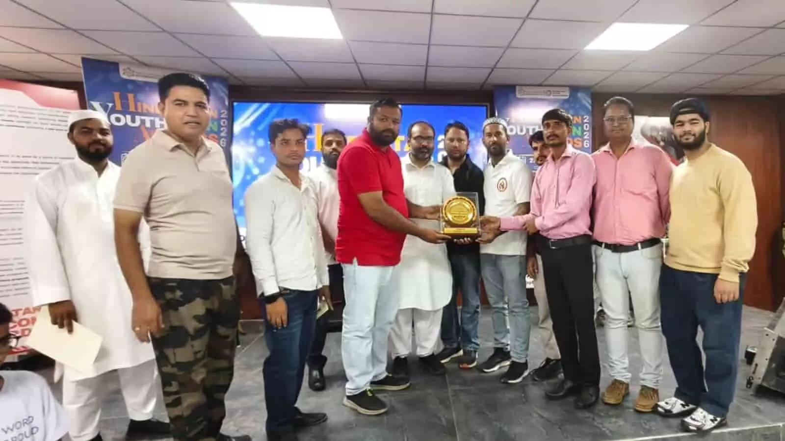 विश्वविद्यालय हॉल में पुरस्कार प्राप्त करते हेल्पिंग हैंड ब्लड हेल्पलाइन टीम के सदस्य।