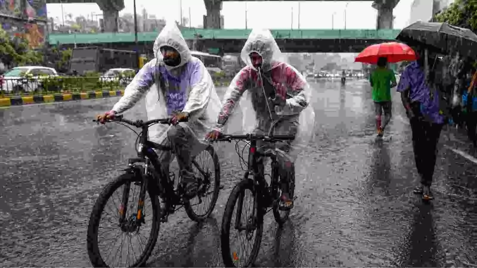 बरसात के मौसम में रेनकोट पहने हुए लोग साइकिल चलाते हुए दक्षिण भारत के एक शहर में| बरसात के मौसम में रेनकोट पहने हुए लोग साइकिल चलाते हुए दक्षिण भारत के एक शहर में|